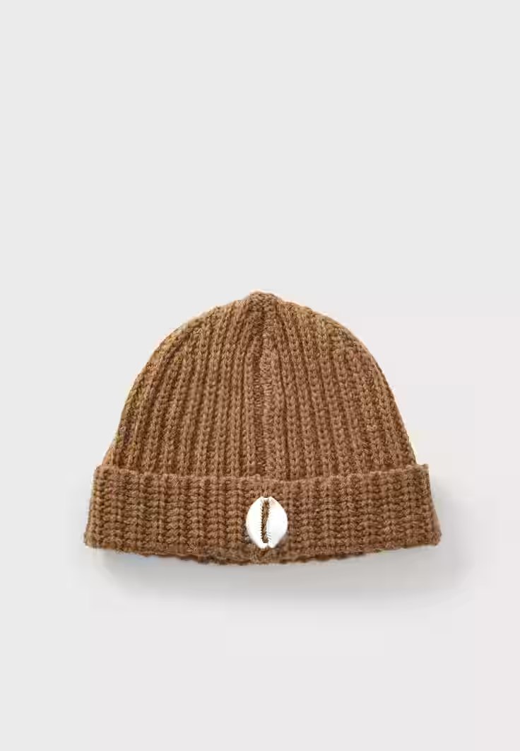 Brown ribbed knit beanie with a white cowrie emblem